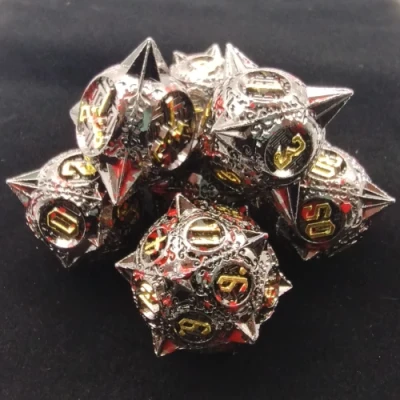 Spiky metal dice: bloodied black with gold numbers in a black suedecloth bag